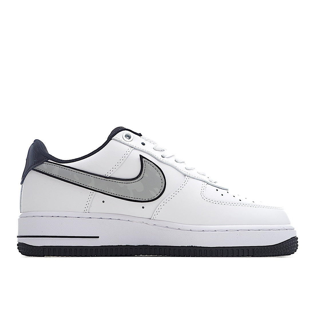 White low-top sneaker with navy heel and black Swoosh, side profile.