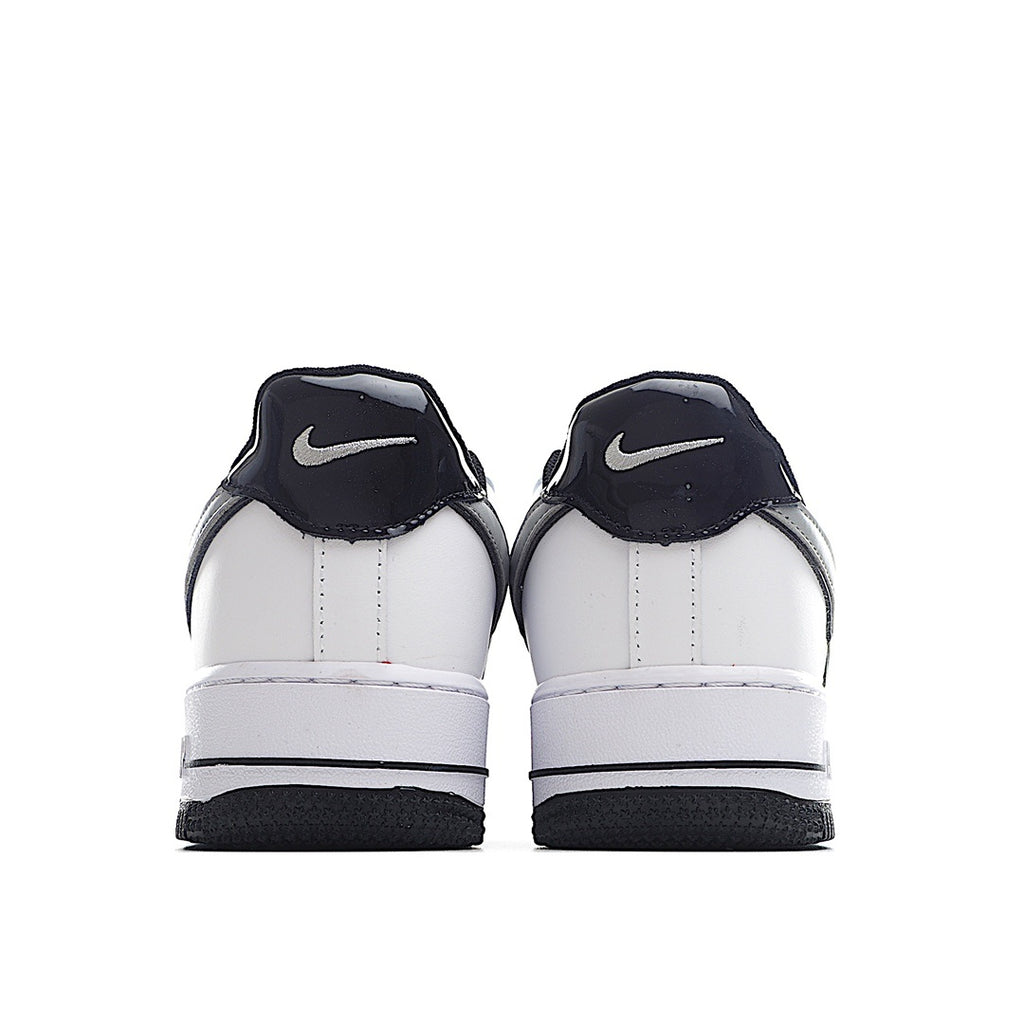 White low-top sneaker pair heel view with navy Nike Swoosh on back.