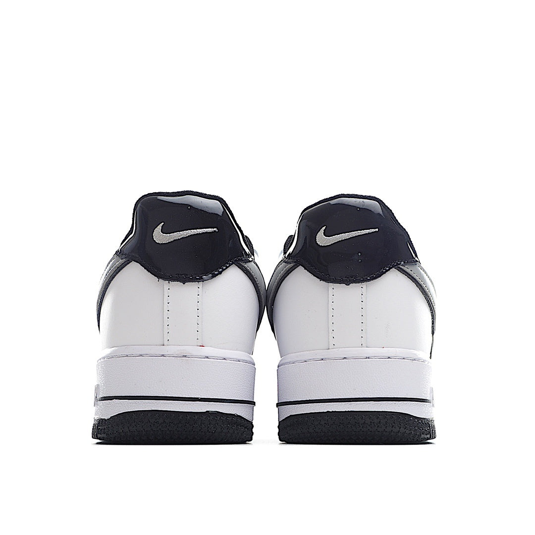 White low-top sneaker pair heel view with navy Nike Swoosh on back.