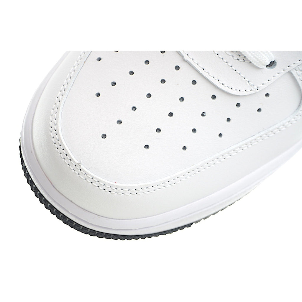 White toe box with perforation holes and stitched edge, side close-up.