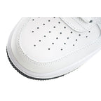 White toe box with perforation holes and stitched edge, side close-up.