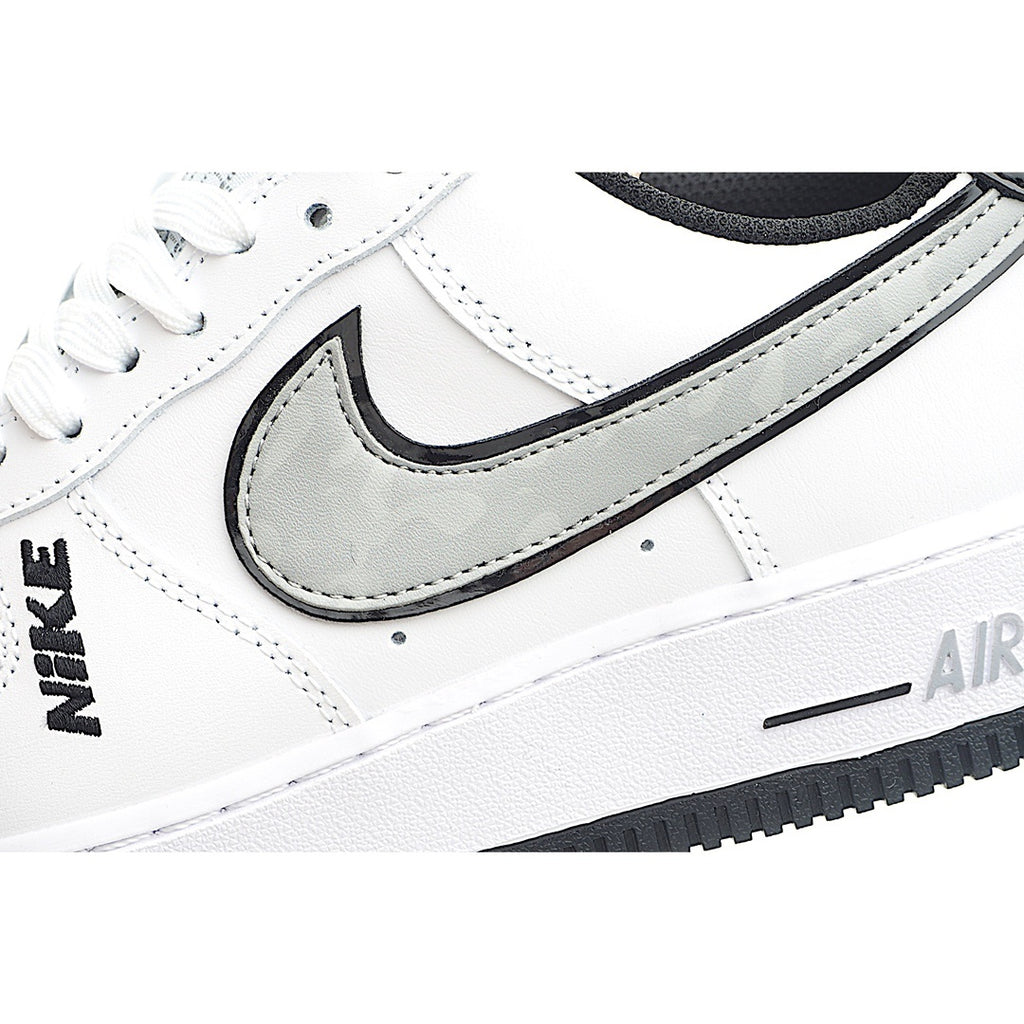 White low-top sneaker with black Swoosh and navy collar, side close-up.