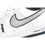 White low-top sneaker with black Swoosh and navy collar, side close-up.