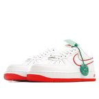 White Air Force 1 sneaker side view with red swoosh, green hanging tag, red outsole