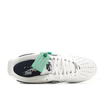 White low-top sneakers with perforated toe, white laces, and green tongue tag