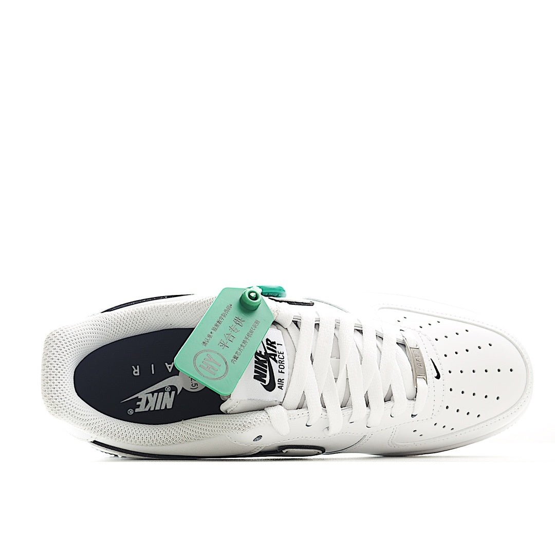 White low-top sneakers with perforated toe, white laces, and green tongue tag