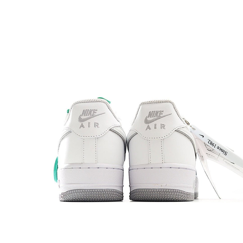 Nike Air Force 1 sneakers, white leather heel view with Air logo and green pull tab