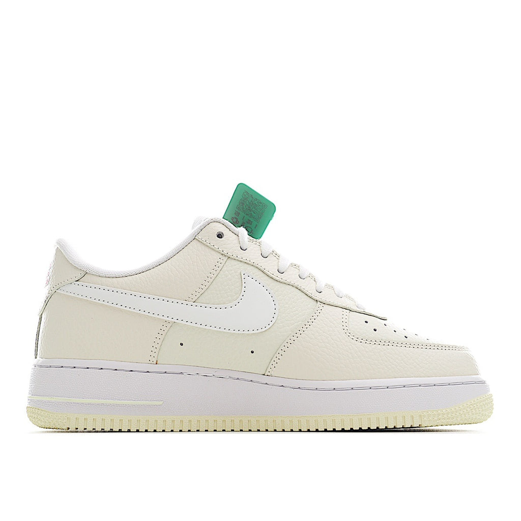 White Nike Air Force 1 sneakers, front quarter view, green hang tag