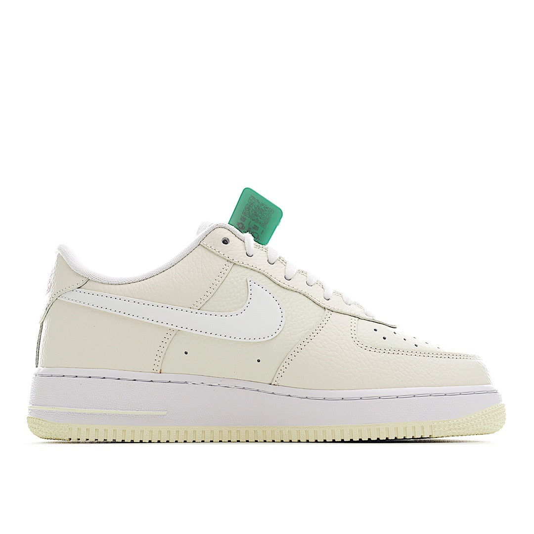 White Nike Air Force 1 sneakers, front quarter view, green hang tag