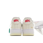 White Nike Air Force 1 sneakers, heel view, green lace pull and Nike logo
