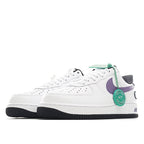 White low-top sneaker with purple swoosh panel, green tag, and black sole edge