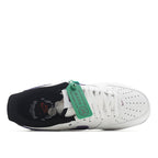 White low-top sneaker with purple swoosh, green tag, dark heel cup, and black sole
