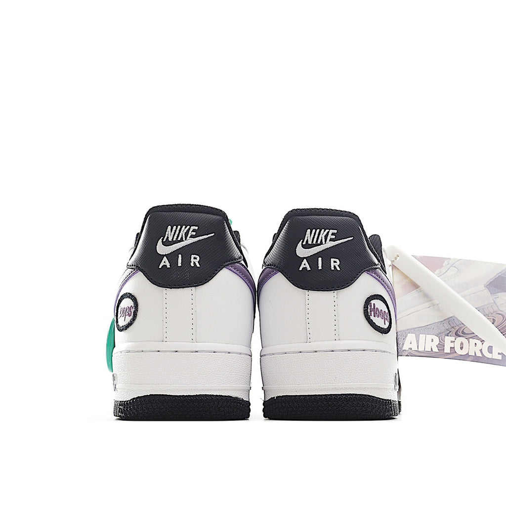 Back view of white low-top sneaker with purple heel accent, green tag, and black sole