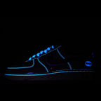 Low-top sneaker with blue glowing trim and black upper, visible swoosh and laces