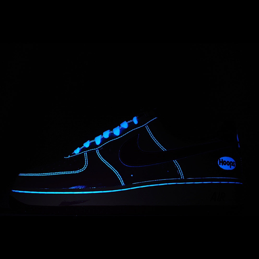 Low-top sneaker with blue glowing trim and black upper, visible swoosh and laces