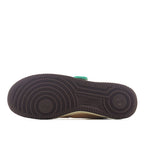 Black rubber outsole tread with circular pattern and green heel tab