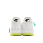 Pair of white low-top sneakers showing heel tabs and neon yellow outsole