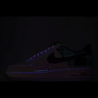 Nike Air Force 1 sneakers, dark upper with green plaid accents and glowing Air logo