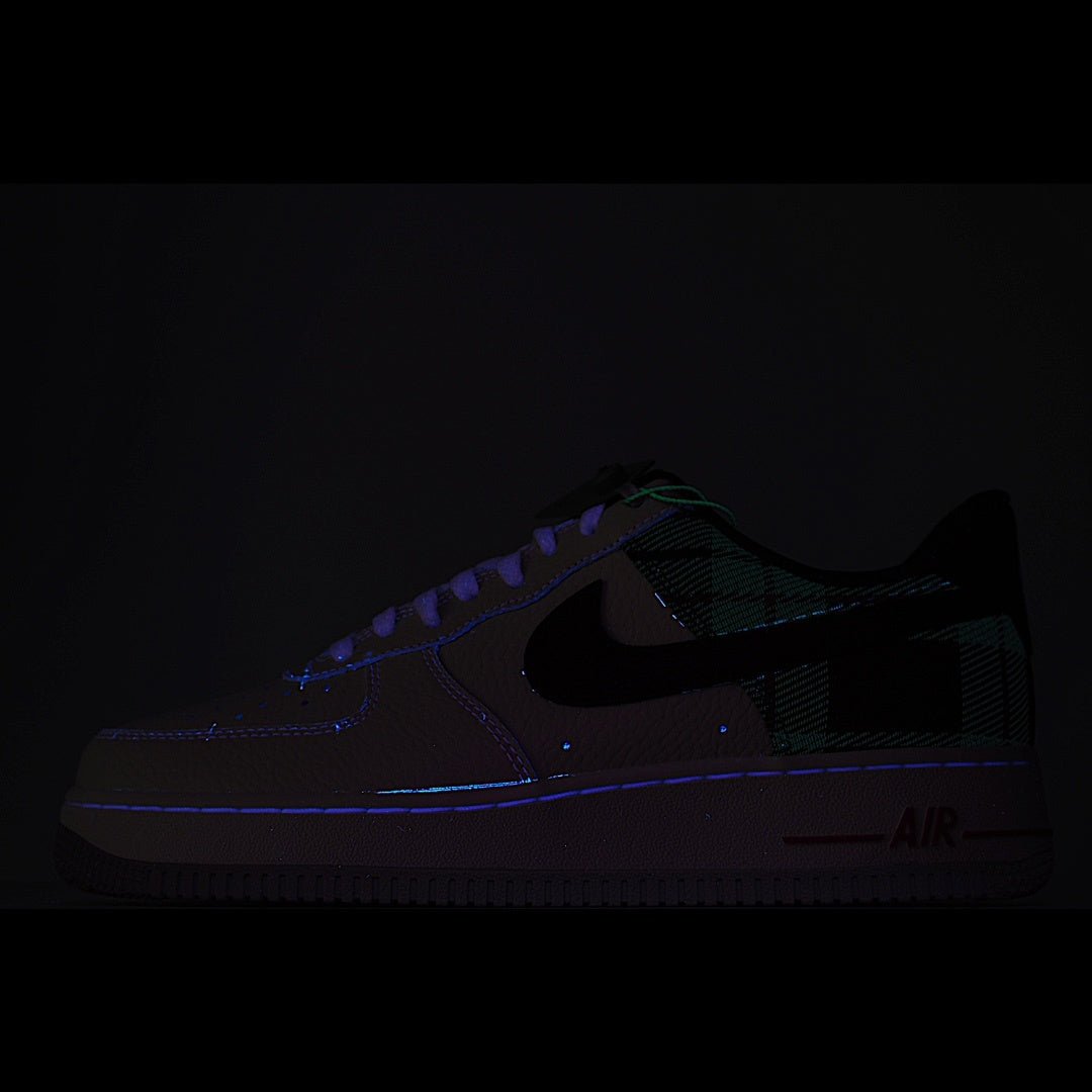 Nike Air Force 1 sneakers, dark upper with green plaid accents and glowing Air logo
