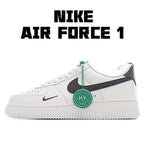 White low-top sneaker with black swoosh and green lace accent