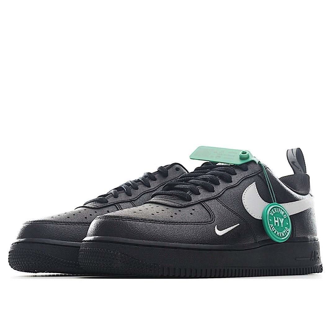 Black low-top sneakers with white heel panel, green HY badge, laced front view