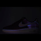 Dark low-top sneaker with blue swoosh and subtle plaid accents, AIR text on side