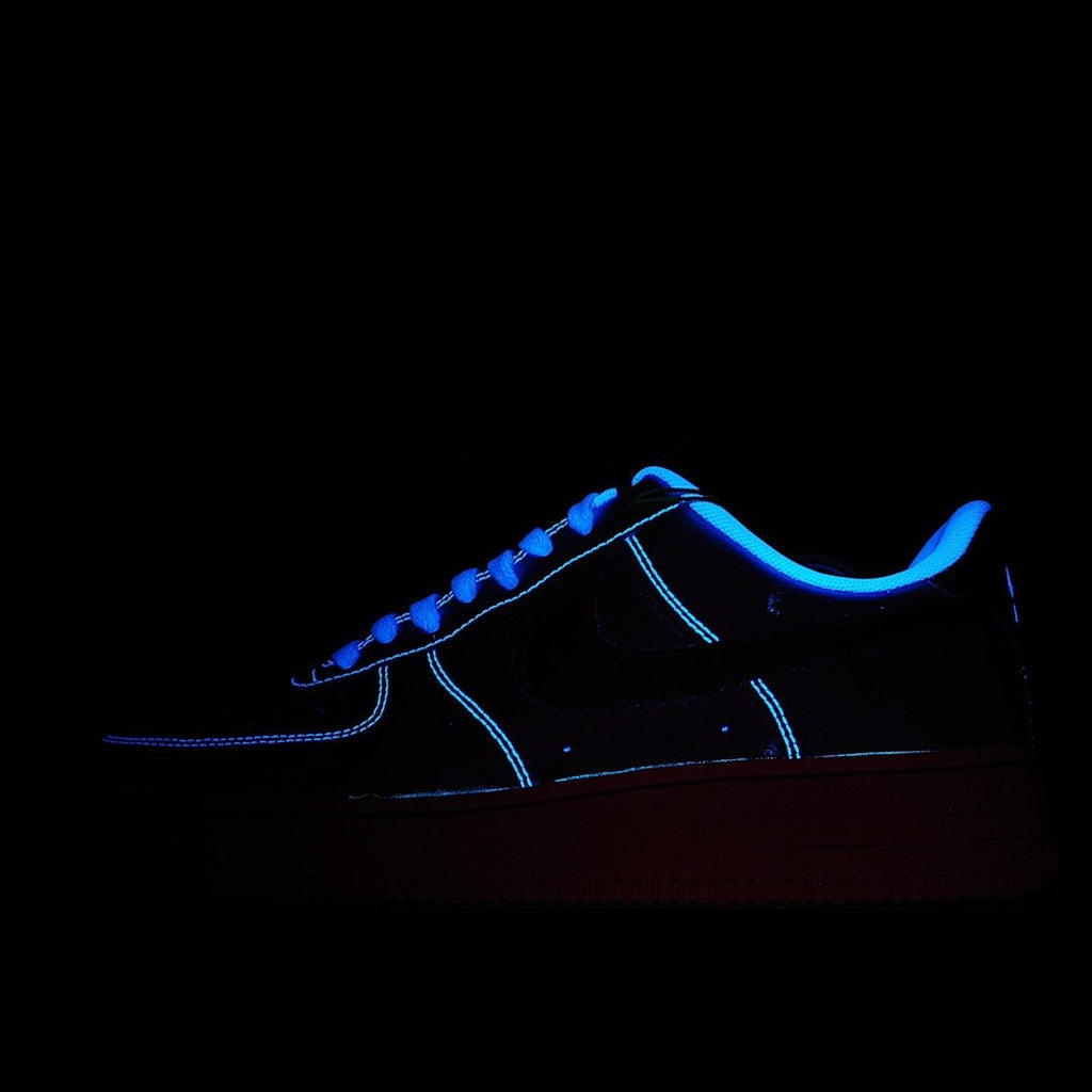 Low-top sneaker, dark upper with neon blue stitching and lace accents