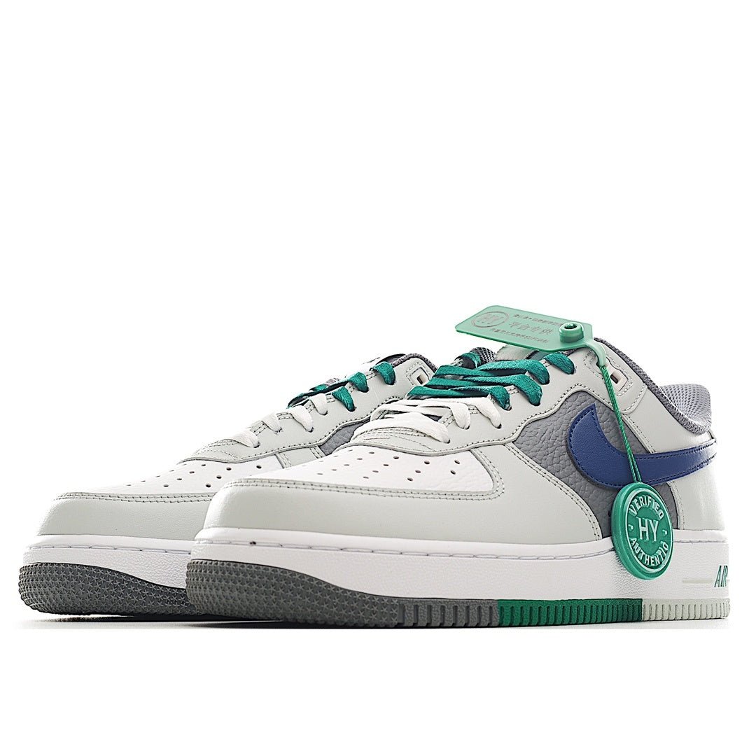 White and light-gray low-top sneaker with blue Swoosh, green laces, green heel accent