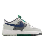 White low-top sneaker with blue Swoosh, gray panels, and green lace trim