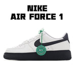 Low-top sneaker in white with black swoosh and green lace tag, black rubber sole.