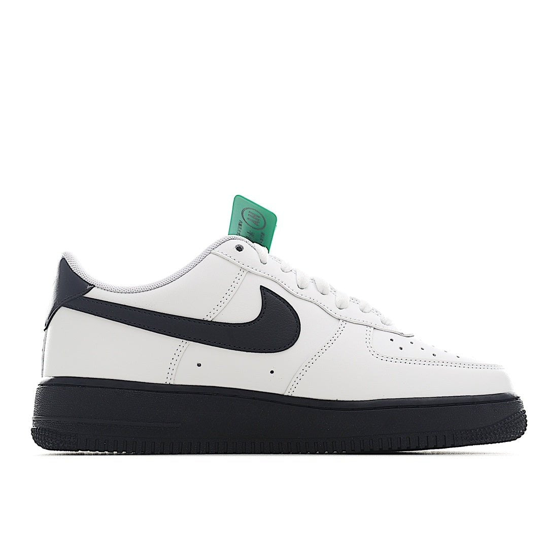 Low-top sneaker with black swoosh on white upper, green lace tag, black sole.