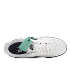 Low-top sneaker interior view, white laces and upper with dark lining and outsole.