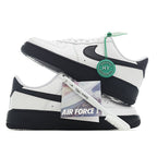 Pair of low-top white sneakers with black swoosh and green lace tag, black soles.