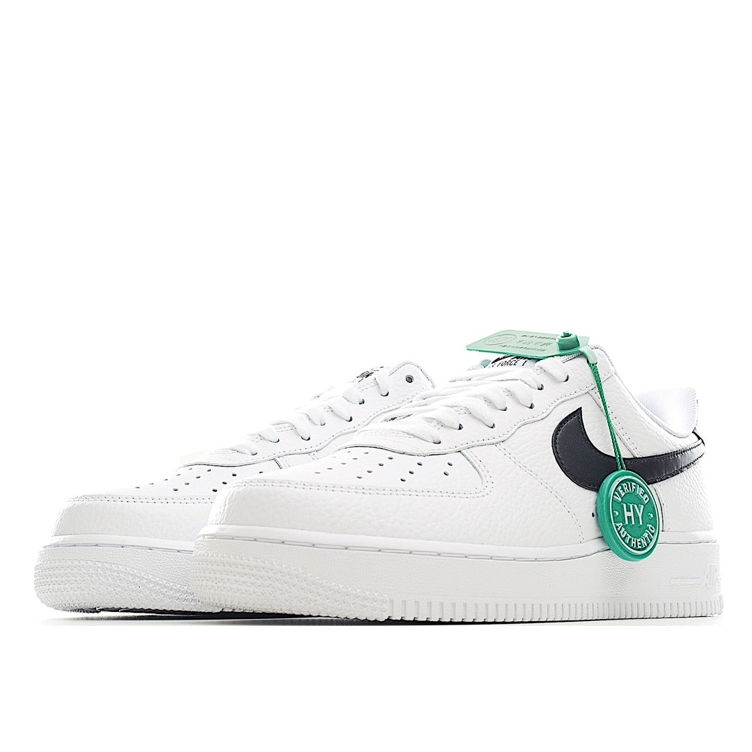 White low-top sneaker with black side swoosh and green lace tag