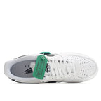 White leather sneaker with white laces, black heel detail, and green collar label