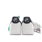 Pair of white sneakers with black heel tabs and green collar accents