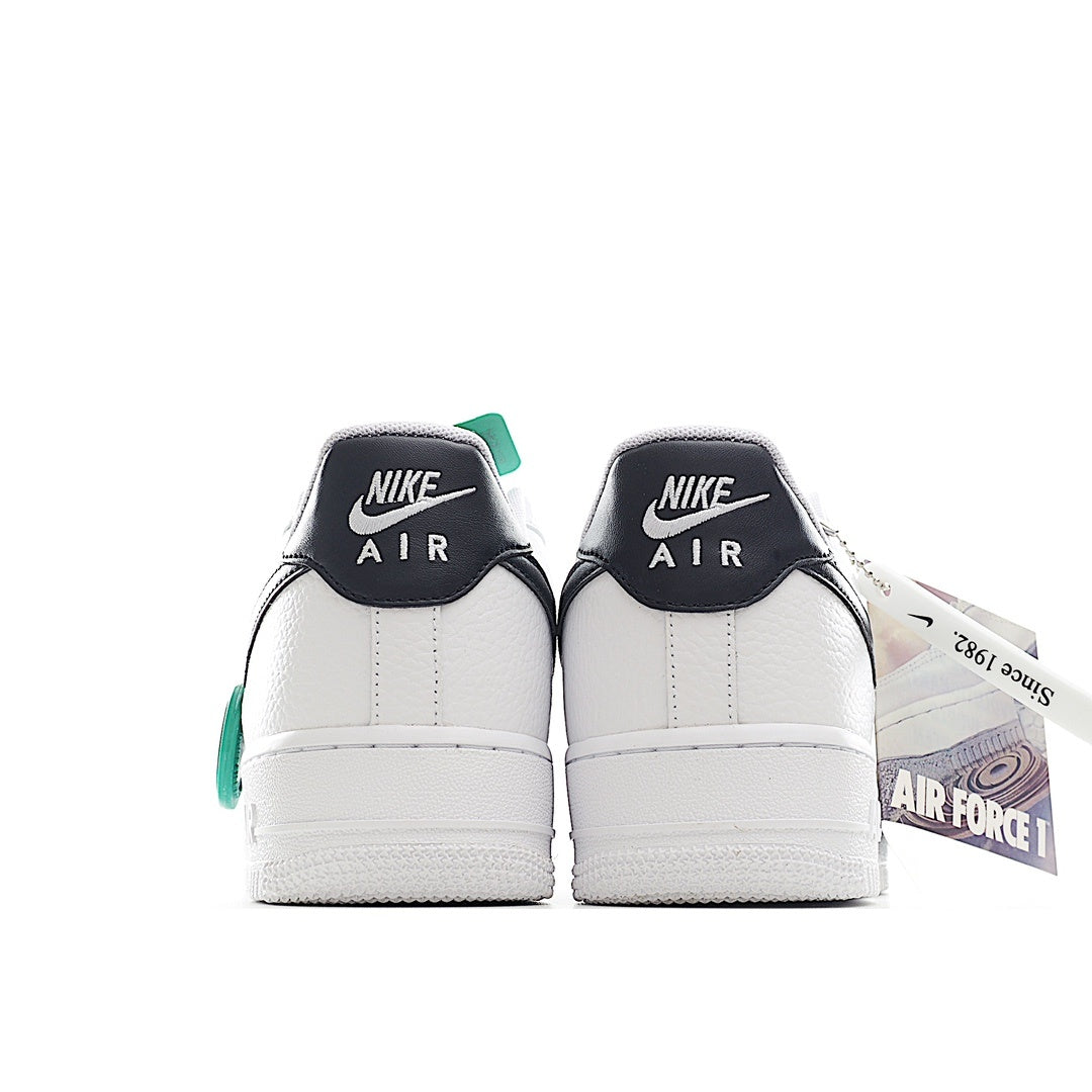 Pair of white sneakers with black heel tabs and green collar accents
