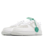 White Nike Air Force 1 low-top sneakers with teal tag at laces