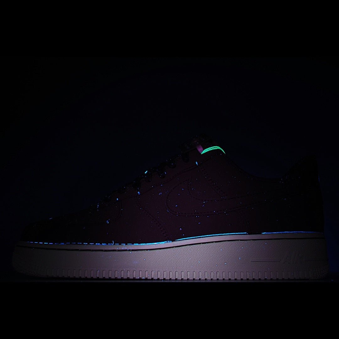 Nike Air Force 1 low-top sneaker in dark lighting, dark upper with green accent and white sole