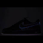 Nike Air Force 1 sneakers, dark upper with blue glowing swoosh and AIR branding.