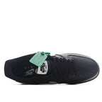 Low-top sneakers, black upper with white swoosh and outsole branding visible