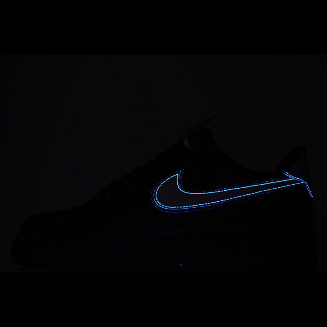 Low-top sneakers in black with blue swoosh outline on a dark background
