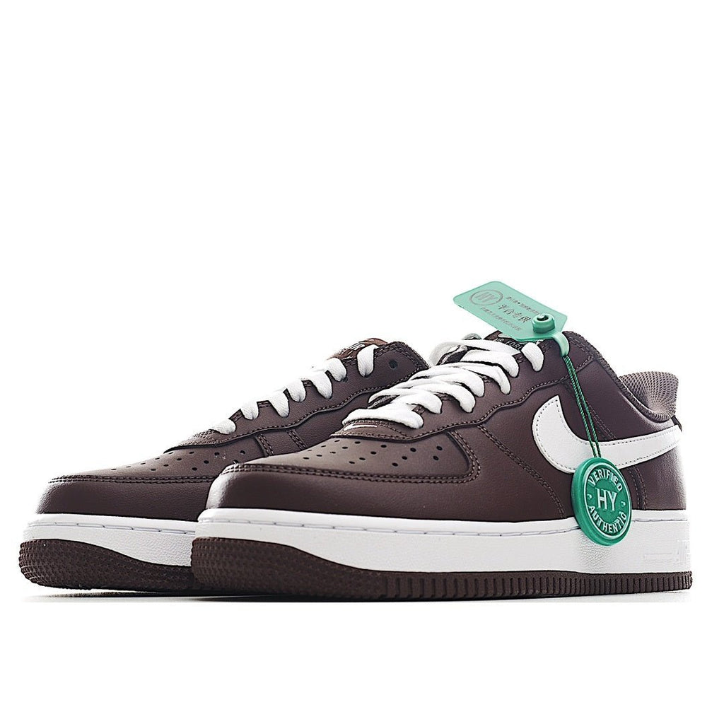 Pair of brown Nike low-top sneakers with white swoosh, green lace tag, and side panels