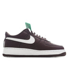 Brown Nike low-top sneaker with white swoosh, green tongue tag, and lace-up closure