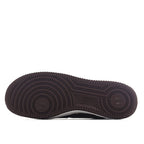 Brown outsole and tread of Nike low-top sneaker, circular traction pattern