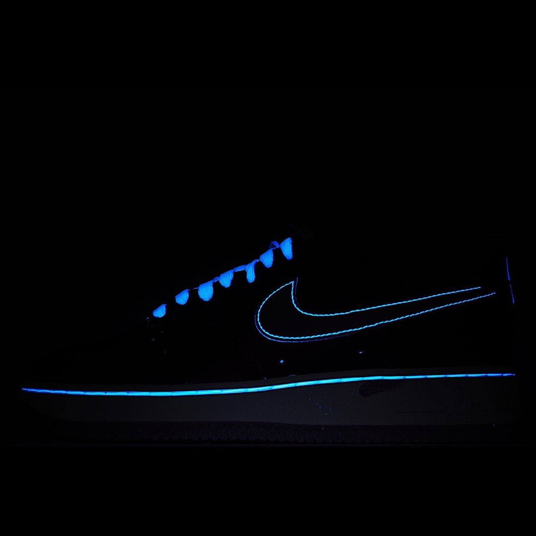 Dark low-top sneaker with glowing blue swoosh detail and blue-tinged laces