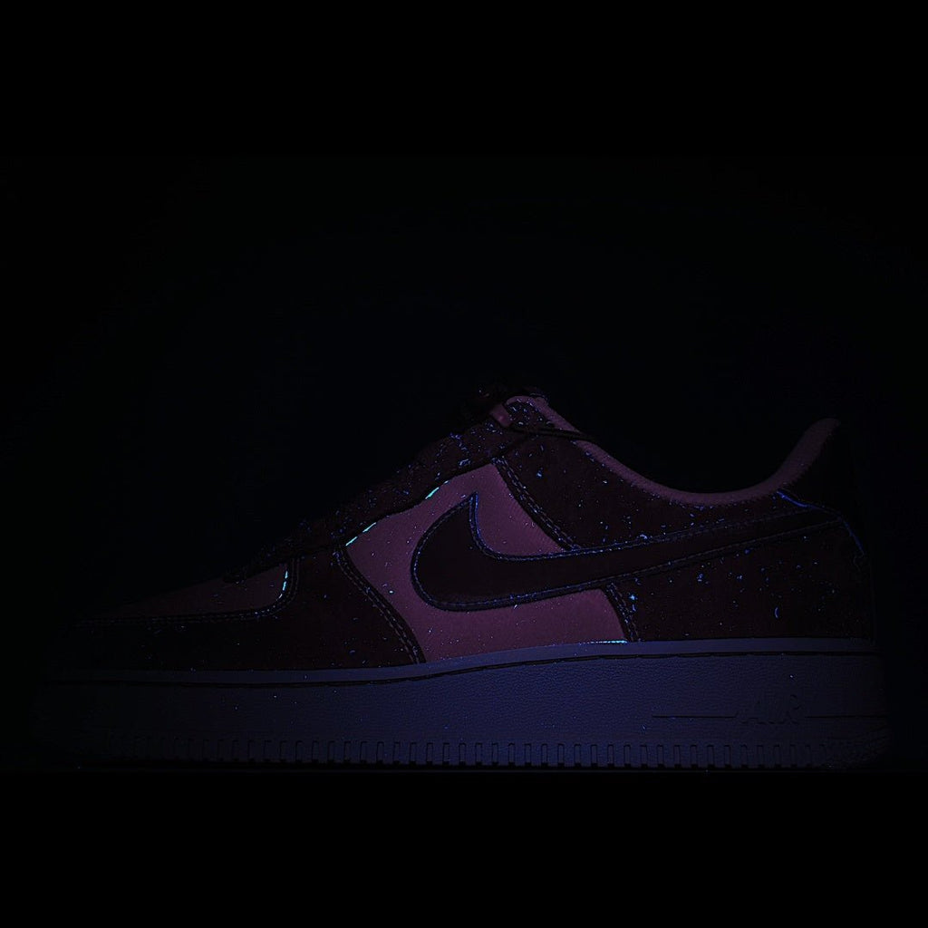 Dark low-top sneaker with purple swoosh and textured midsole detail