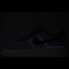 Dark Nike Air Force 1 sneaker with blue glowing accents on panels