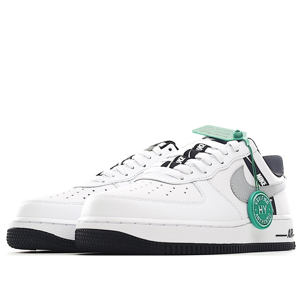 White Nike Air Force 1 sneakers with gray swoosh and green collar accents.