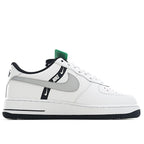 White Nike Air Force 1 sneakers with black swoosh and green collar tab.